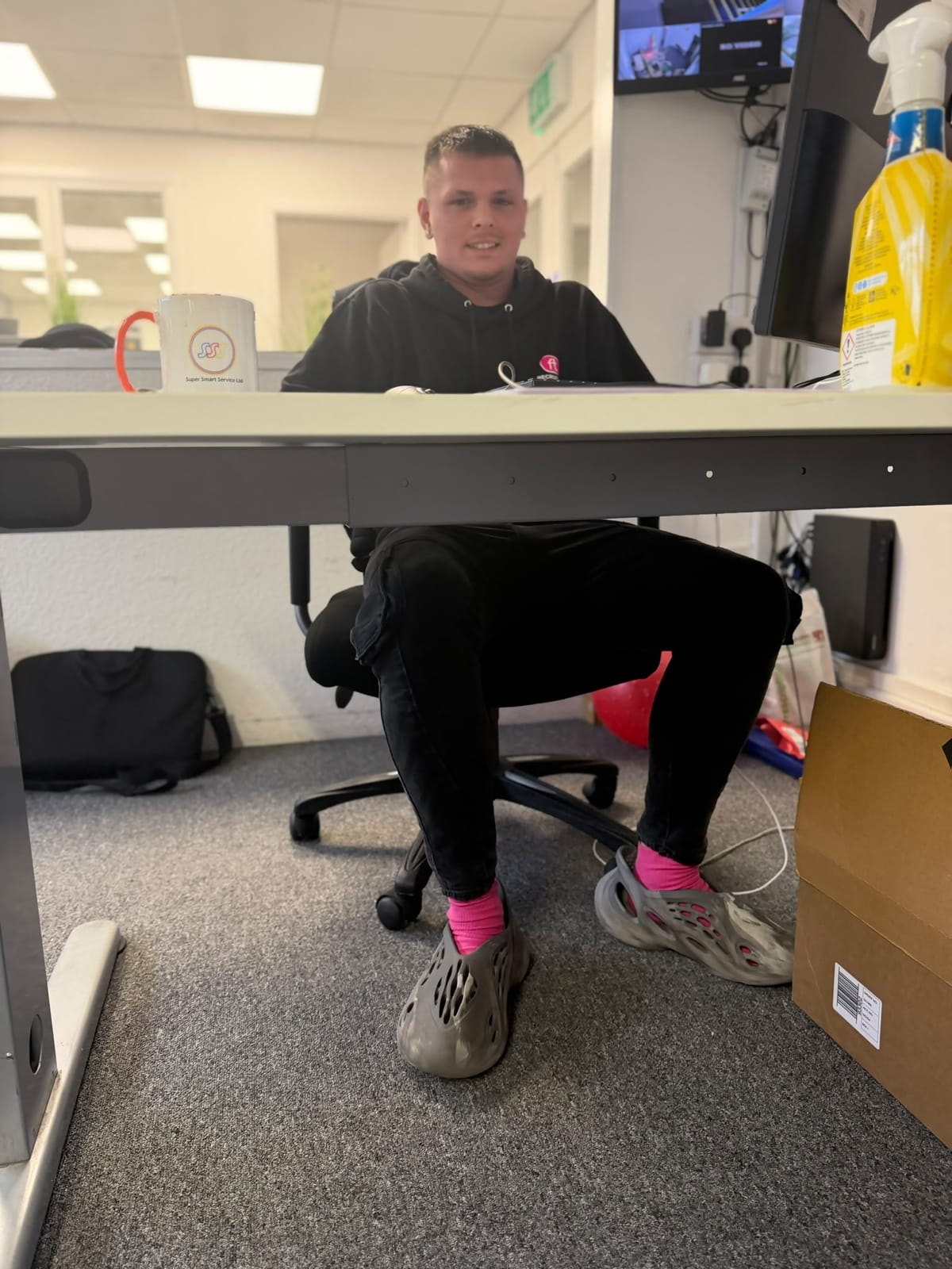 FT Recruitment team member at a desk showing off bright pink socks