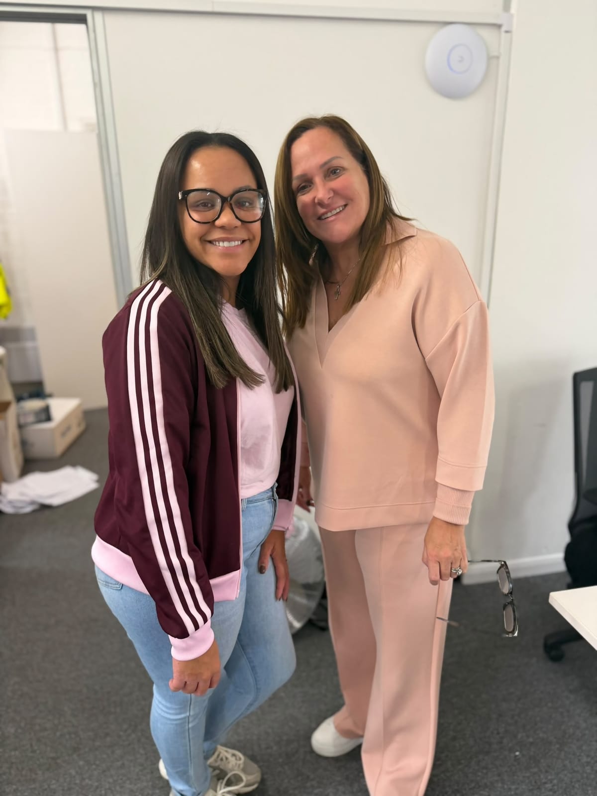 Two FT Recruitment colleagues in pink standing together in the office