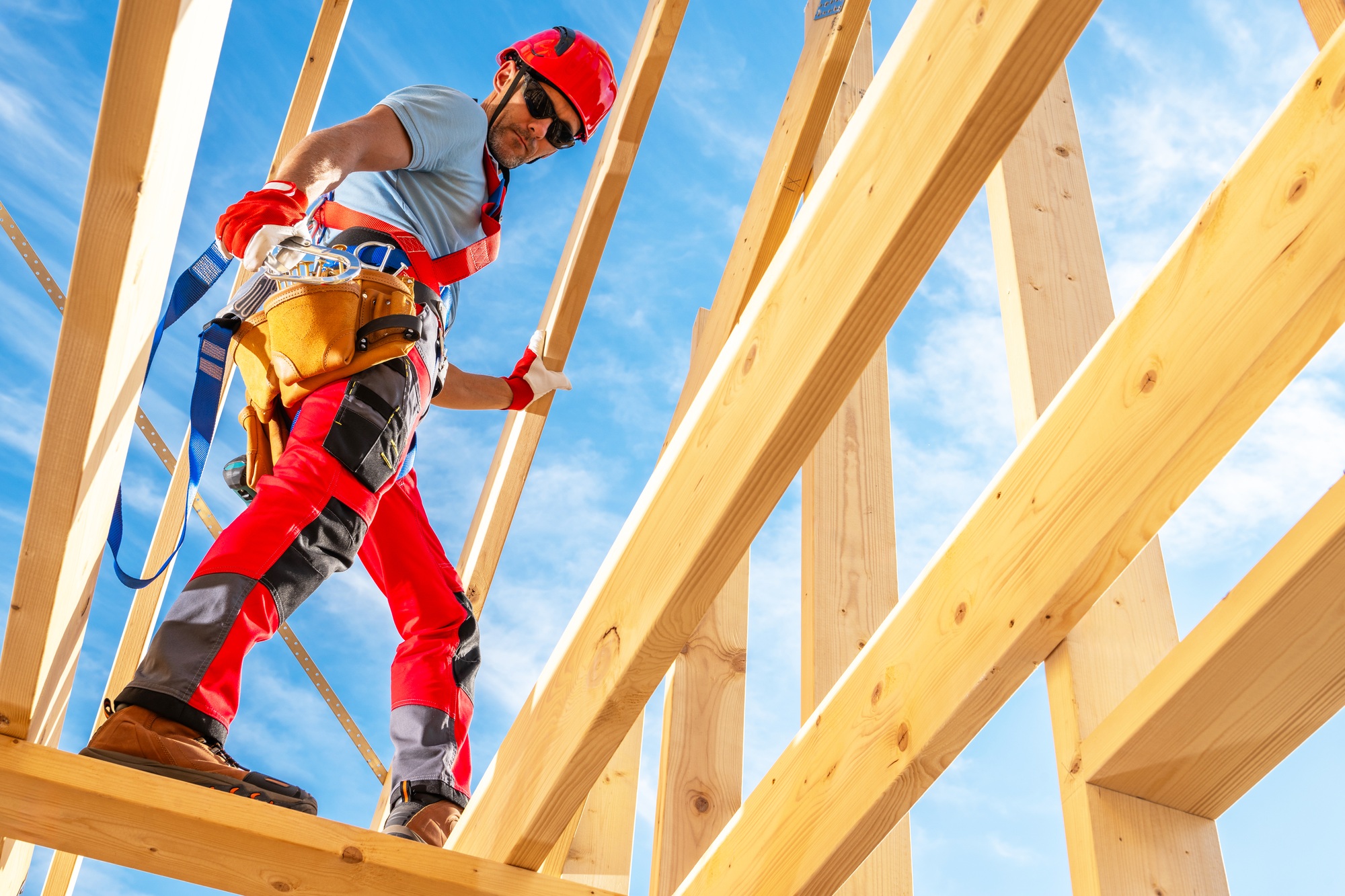 Worker Constructing Wooden Framework Under a Blue Sky During Daytime at a Construction Site